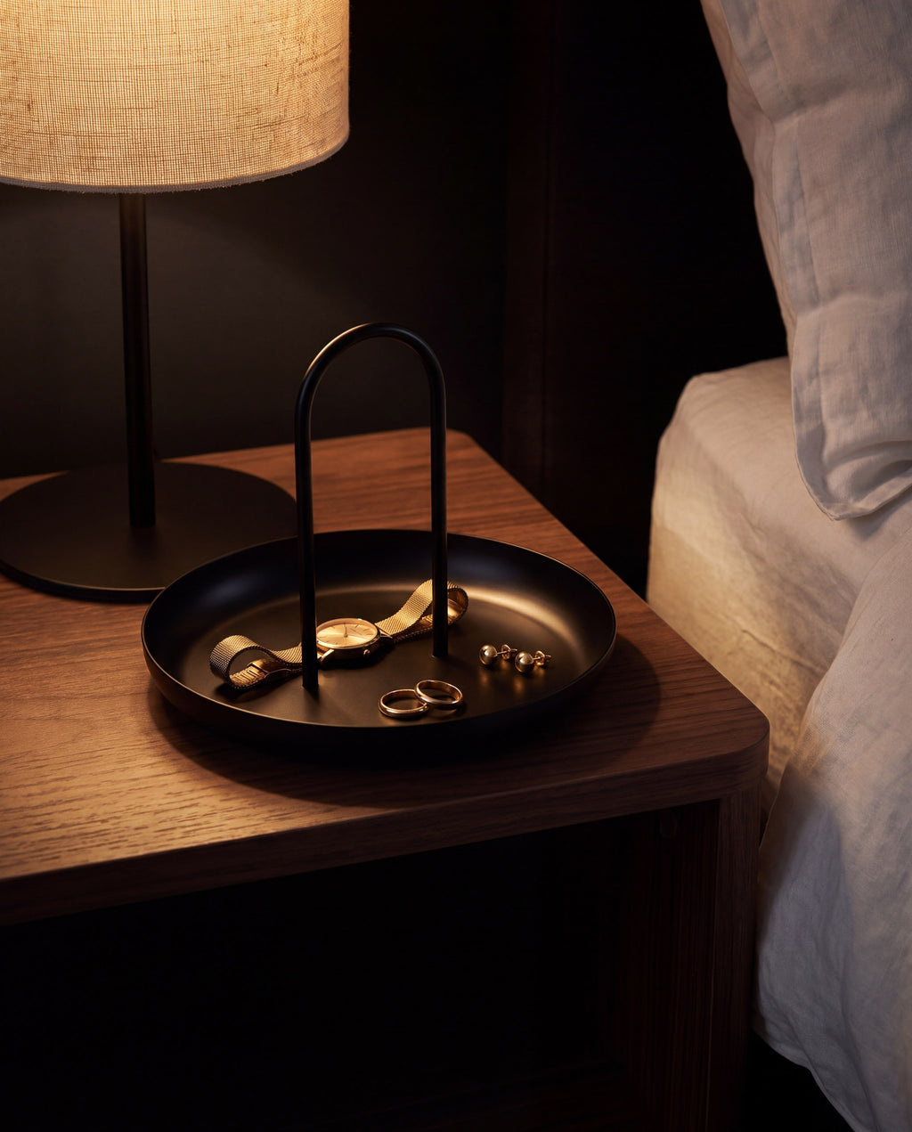 Zivol Arc tray on a bedside table with jewellery under warm lamplight