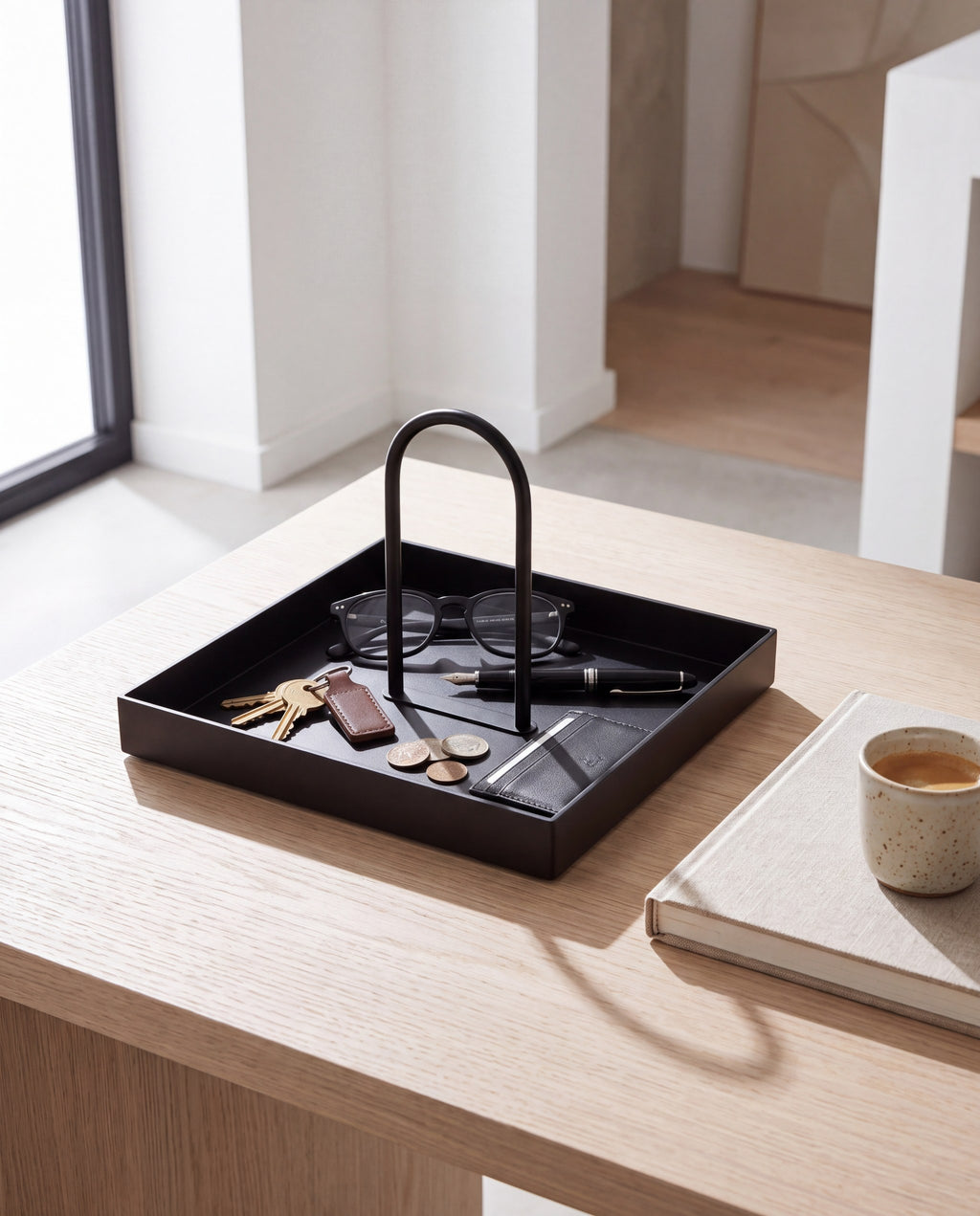 Zivol Arc square matte black tray holding glasses and keys on a pale oak desk