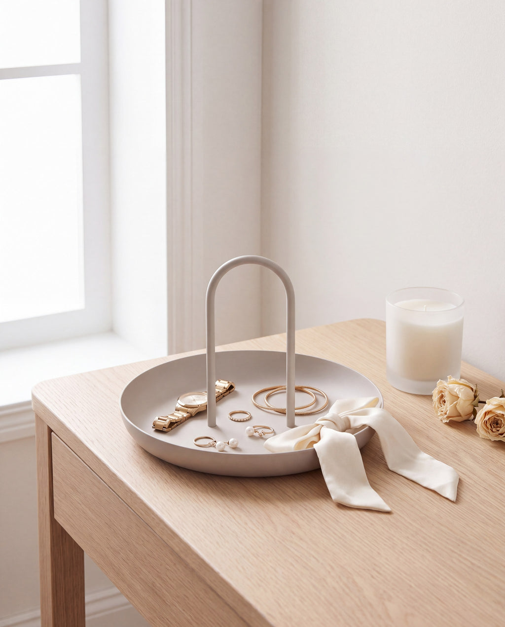 Zivol Arc warm grey tray with jewellery and a silk ribbon on a pale oak dressing table