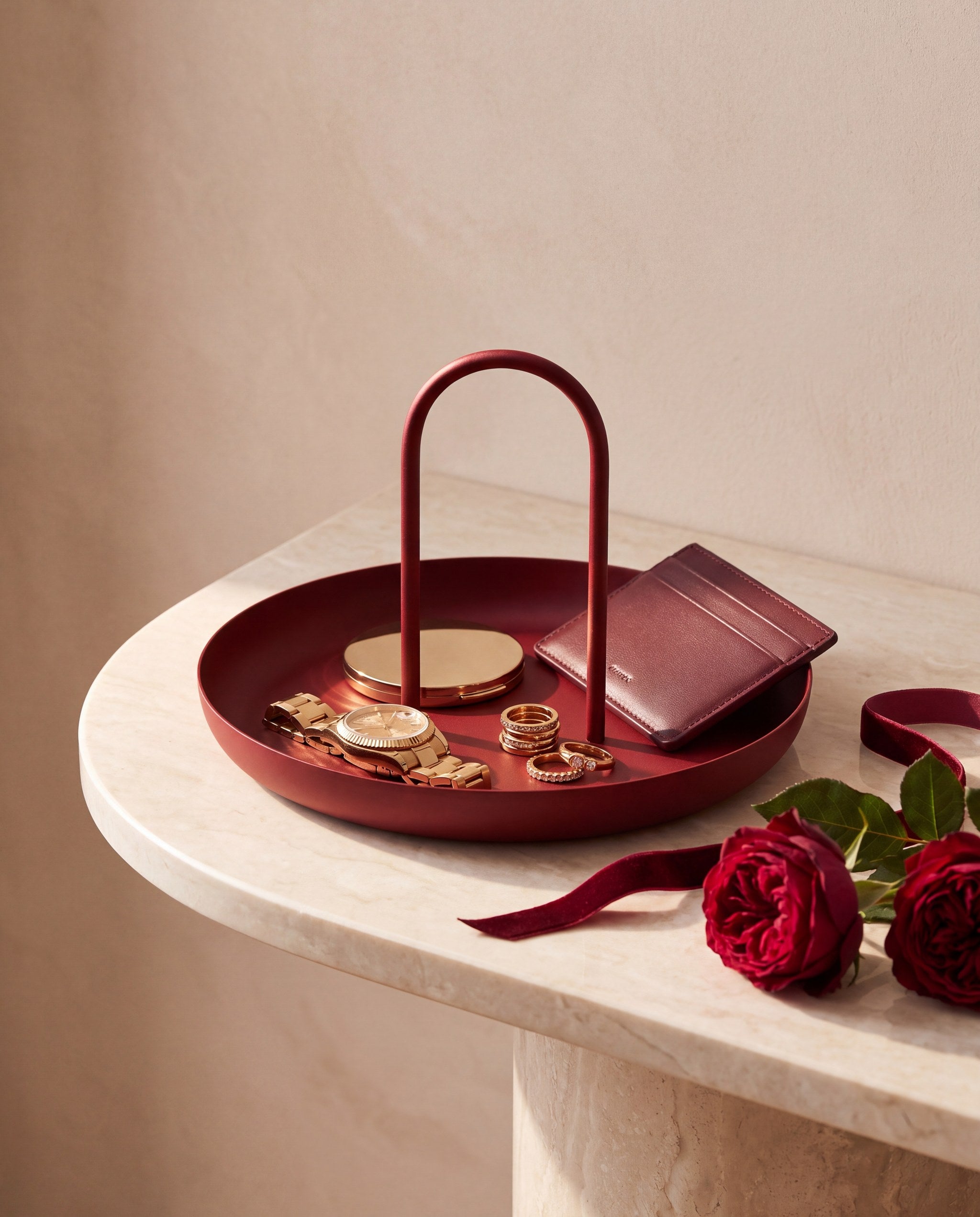 Zivol Arc oxblood red tray with gold jewellery and roses on a cream marble console