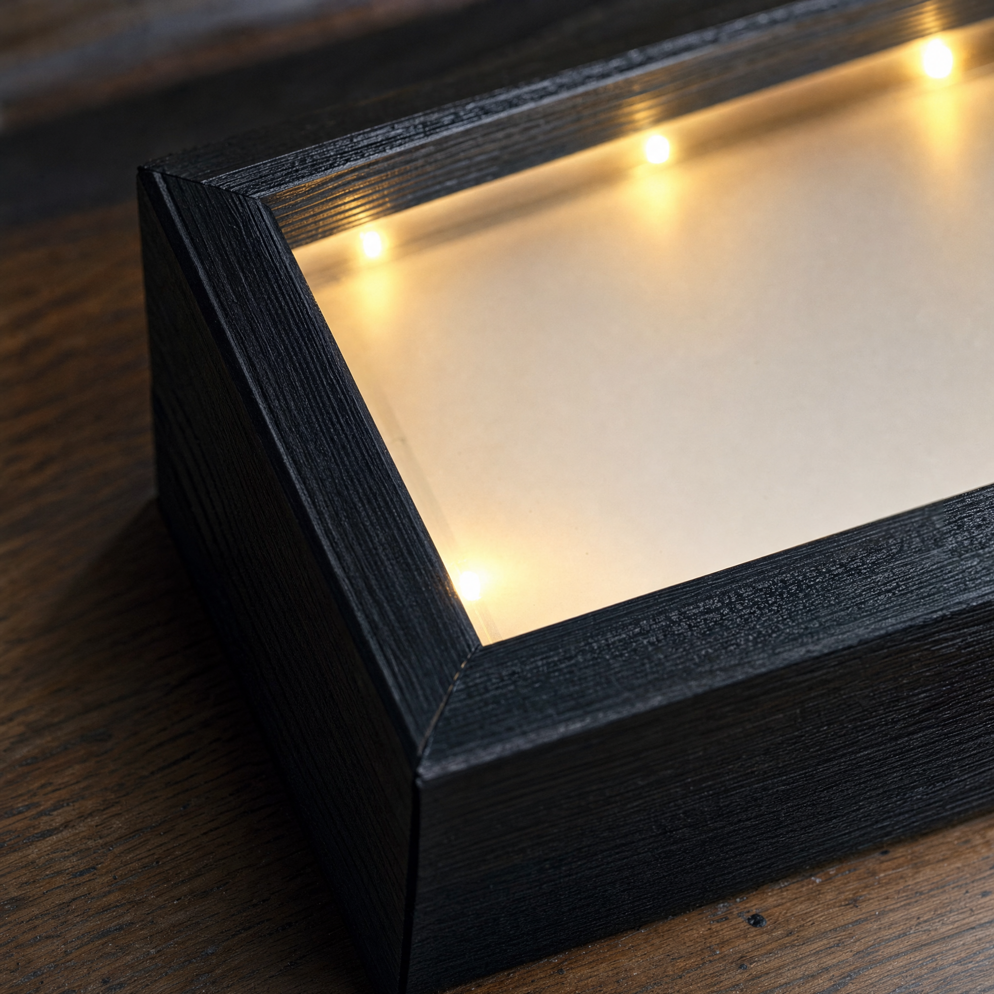 Detail of the torched paulownia wood corner and warm LED points inside the Zivol Echo frame