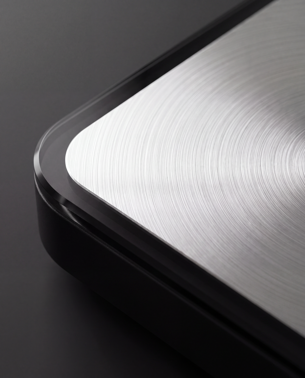 Brushed metal platform meeting tempered glass, close detail