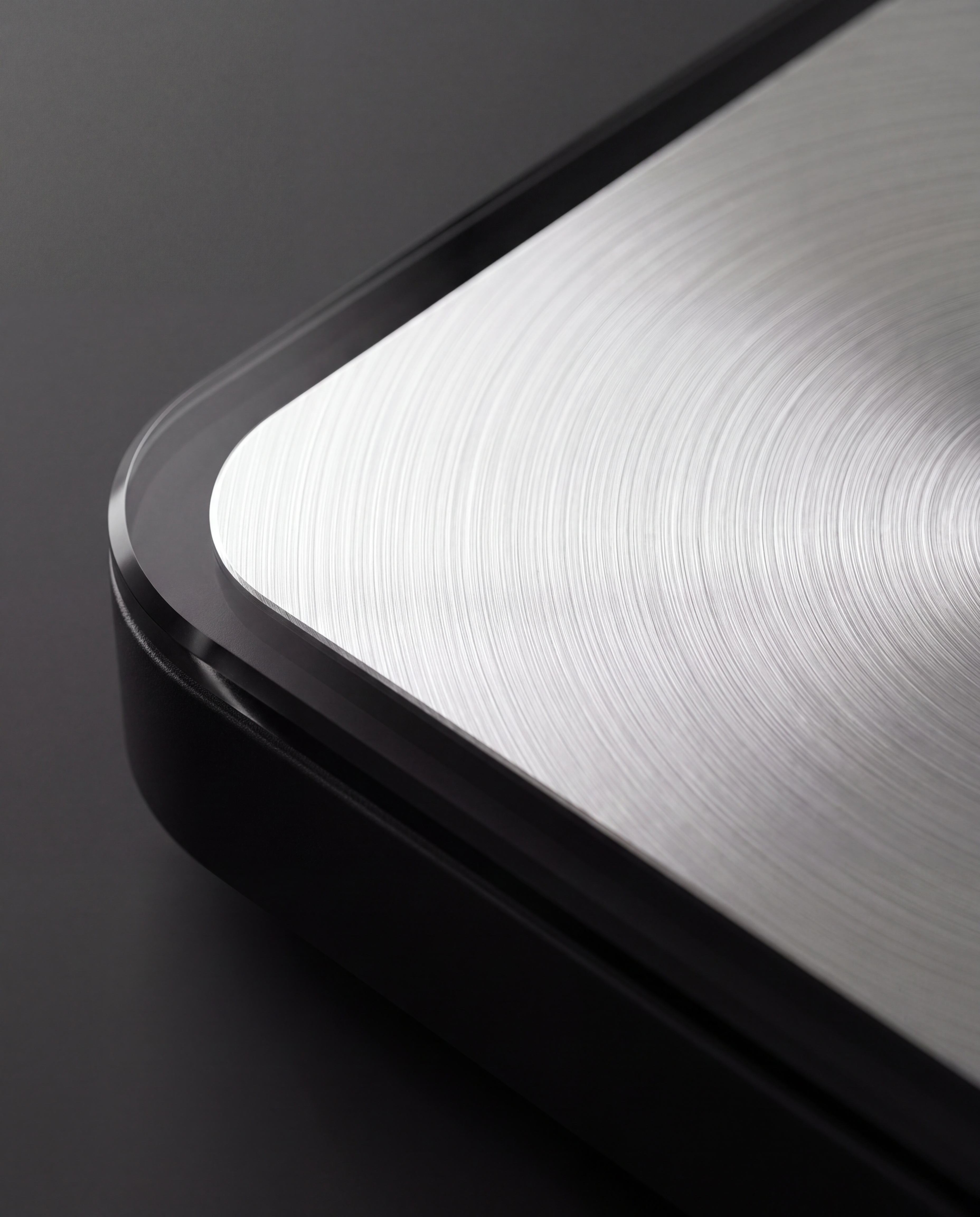 Brushed metal platform meeting tempered glass, close detail