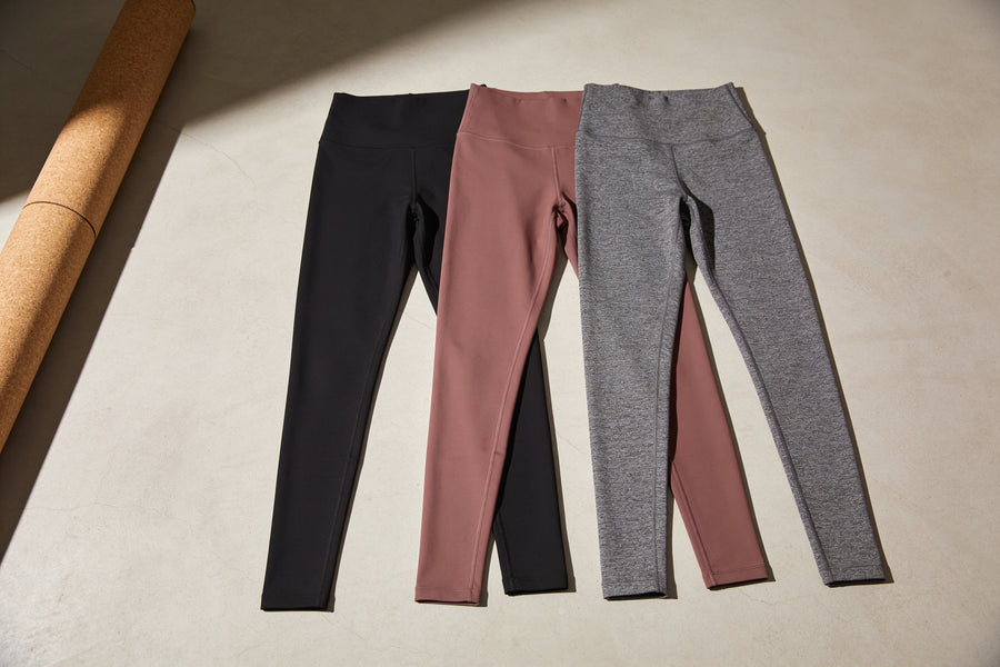 Three colourways of Zivol Claim leggings laid out flat: black, dusty rose pink and heather grey