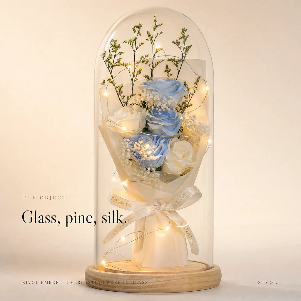 Zivol Ember everlasting rose in a tall glass dome on a pale wood base