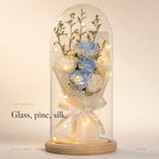Zivol Ember everlasting rose in a tall glass dome on a pale wood base